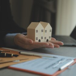 Real,Estate,Agent,And,Customer,Signing,Contract,To,Buy,House,
