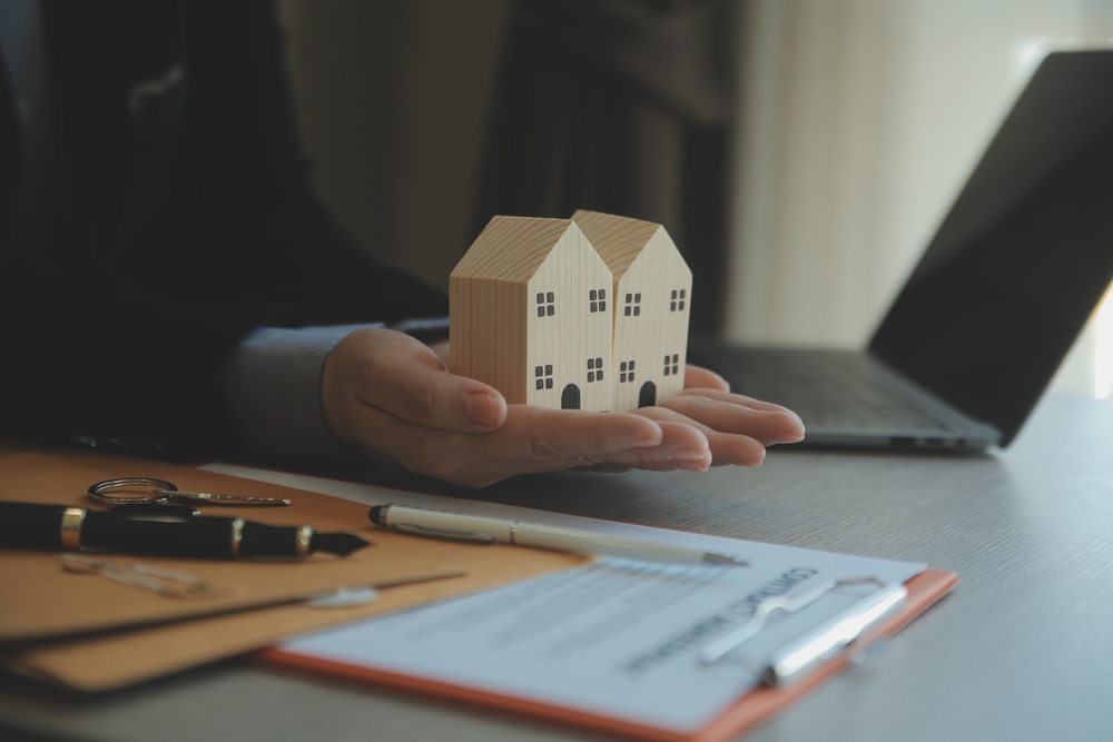 Real,Estate,Agent,And,Customer,Signing,Contract,To,Buy,House,