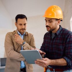 Construction,Worker,Using,Digital,Tablet,With,Home,Owner,During,Renovating